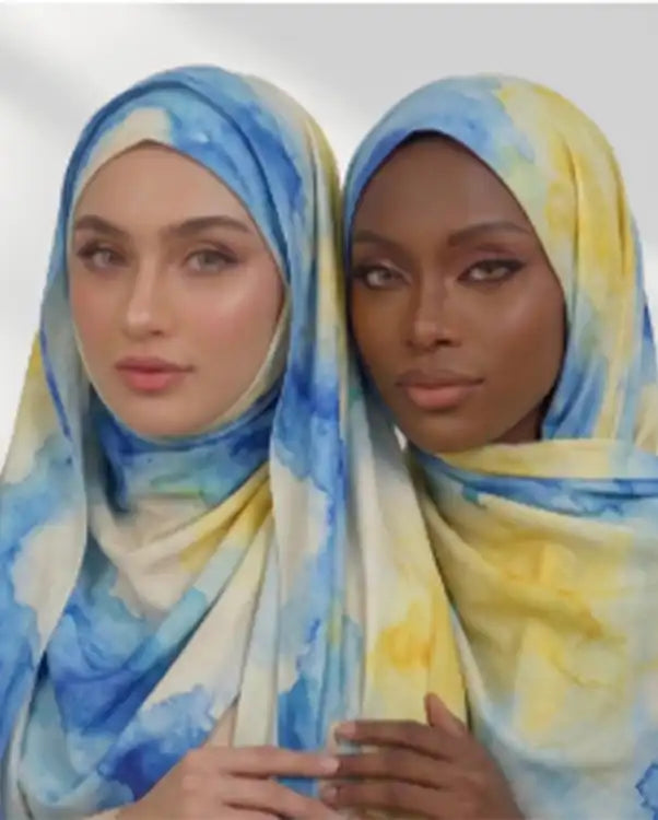 Two women wearing blue and yellow printed modal hijabs