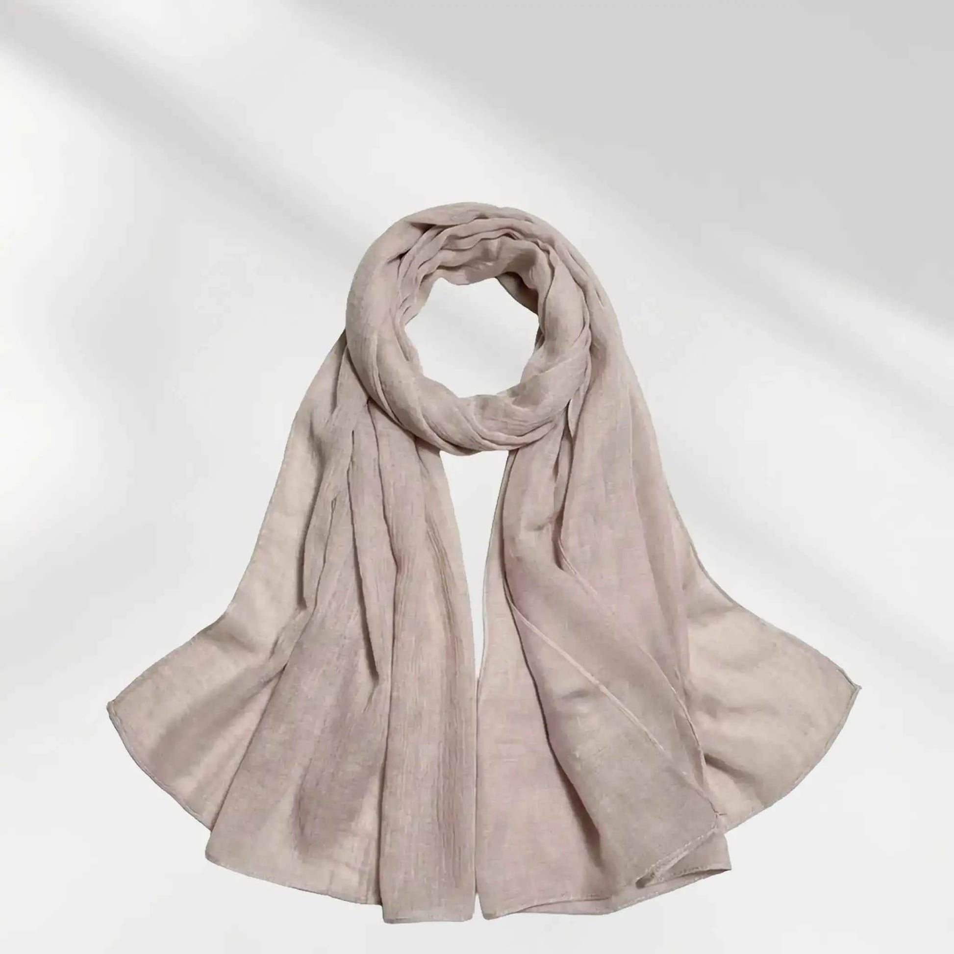 Beige modal hijab scarf coiled and draped on a white background, showing the fabric texture and drape