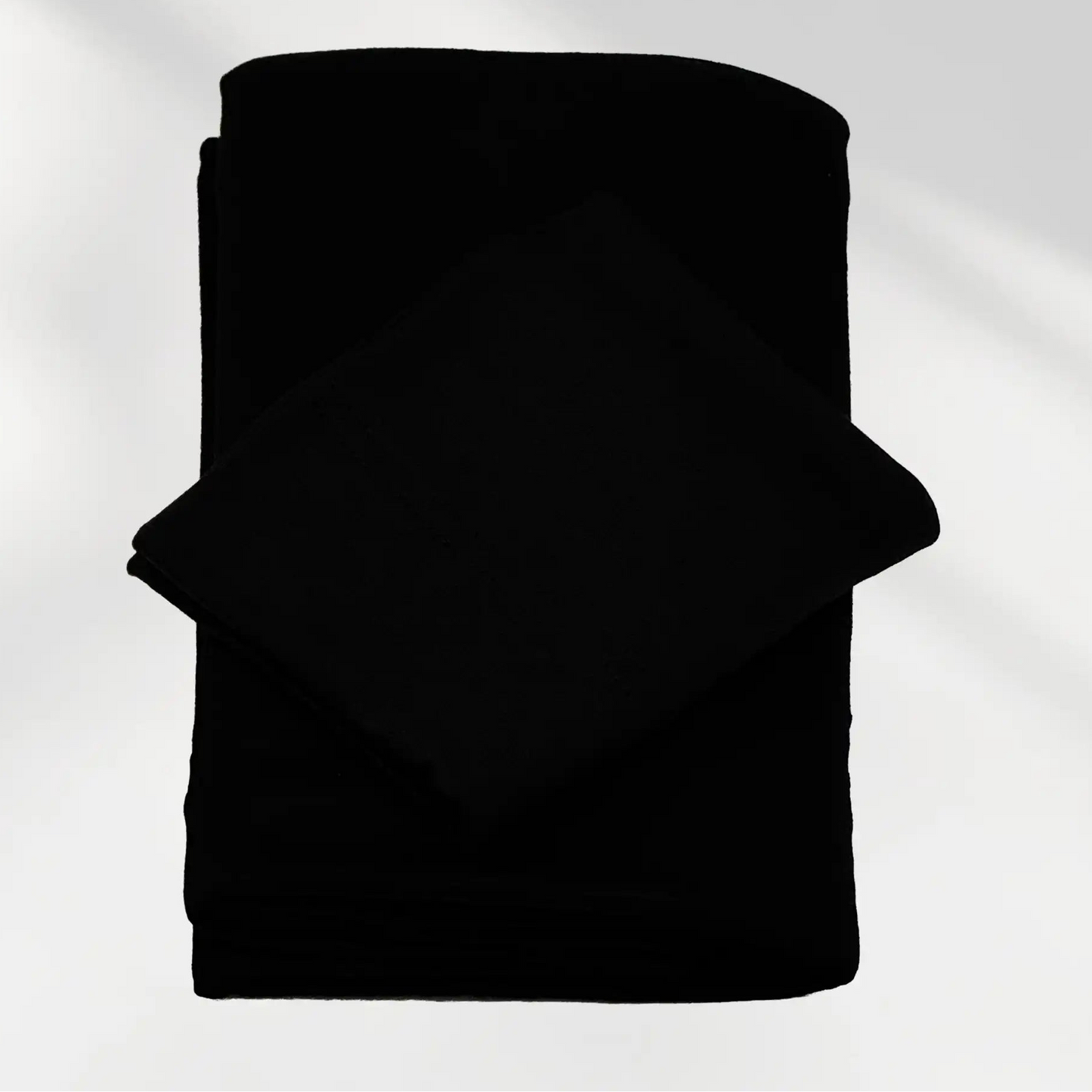 Black jersey hijab and matching hijab cap laid flat, showing the soft stretch fabric