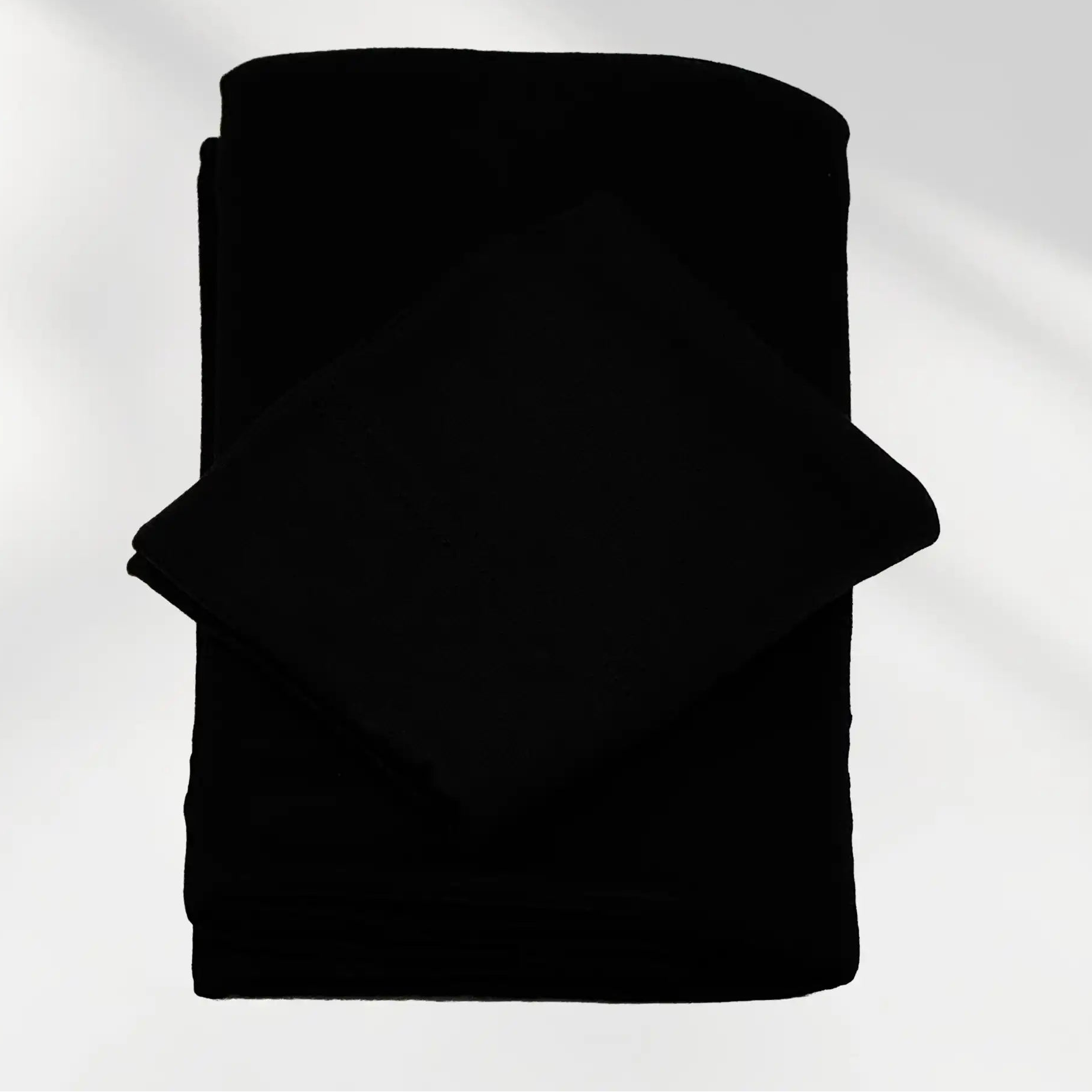 Black jersey hijab and matching hijab cap laid flat, showing the soft stretch fabric
