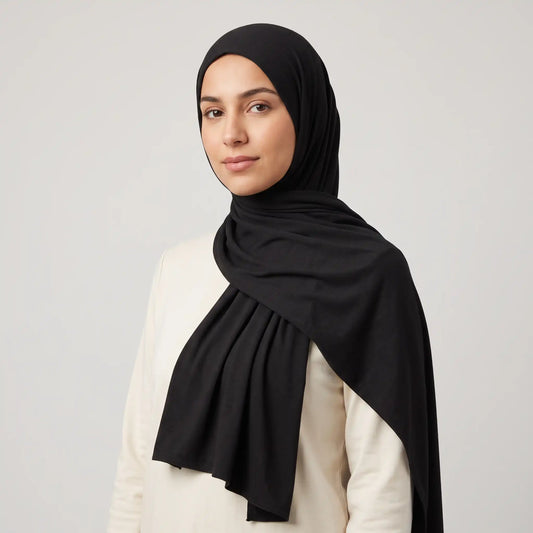 Woman wearing a black jersey hijab with a cream top