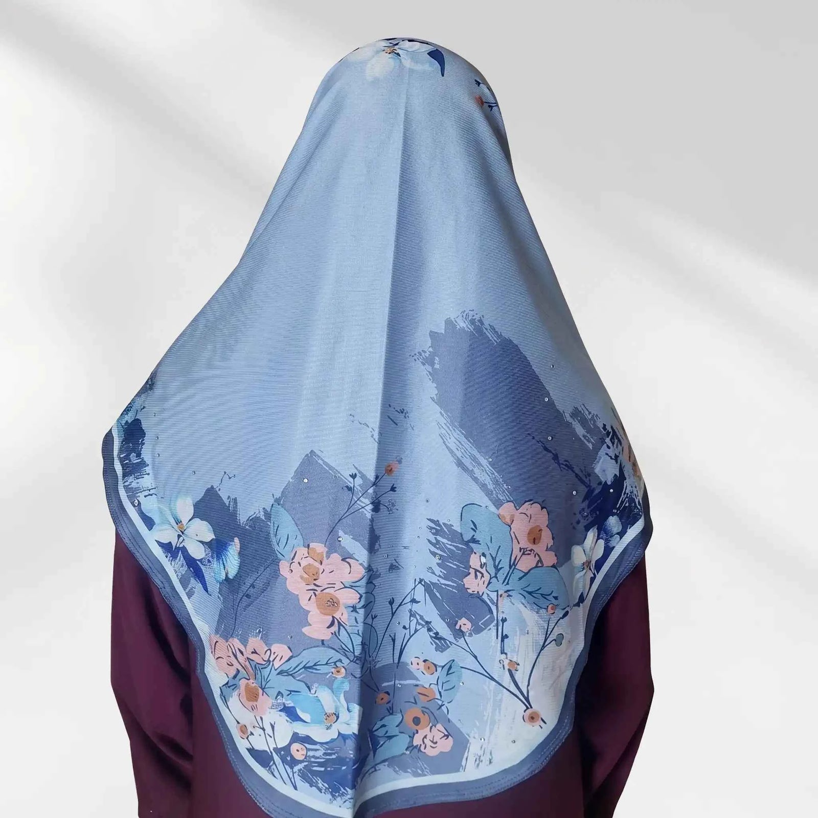 Back view of blue floral instant hijab showing the draped panel with coral peach and ivory watercolor floral border