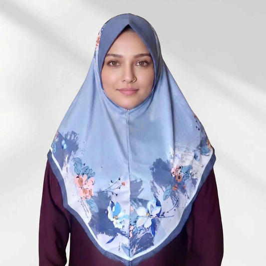 Woman wearing a blue floral instant hijab, front view — one piece slip on hijab with coral peach and ivory watercolor flower border