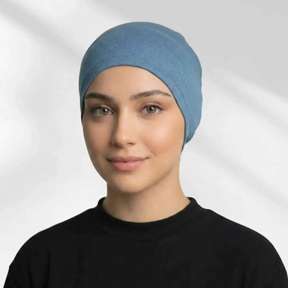 Woman wearing the blue hijab cap on its own, showing full hairline coverage