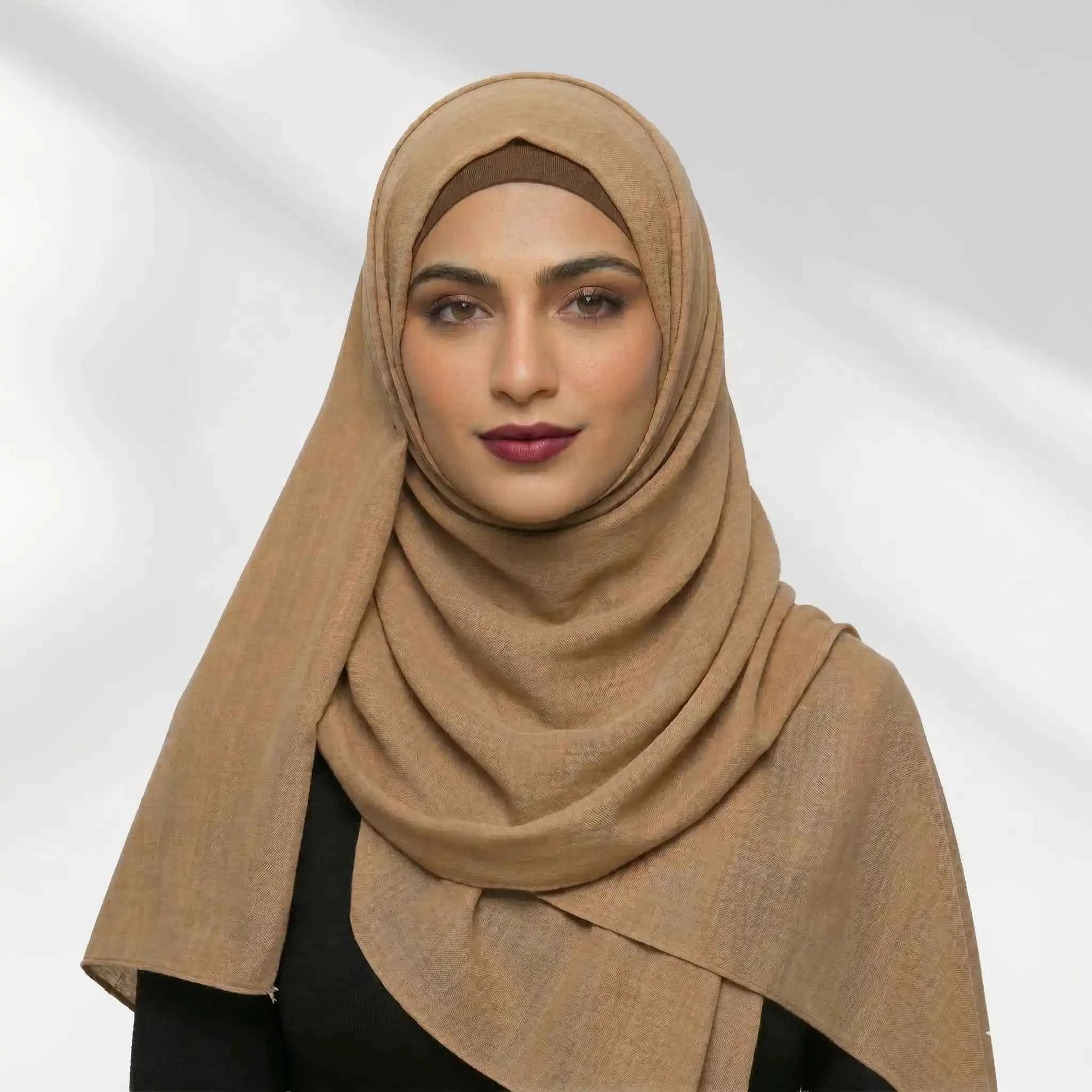 Woman wearing a brown modal hijab styled over a matching hijab undercap
