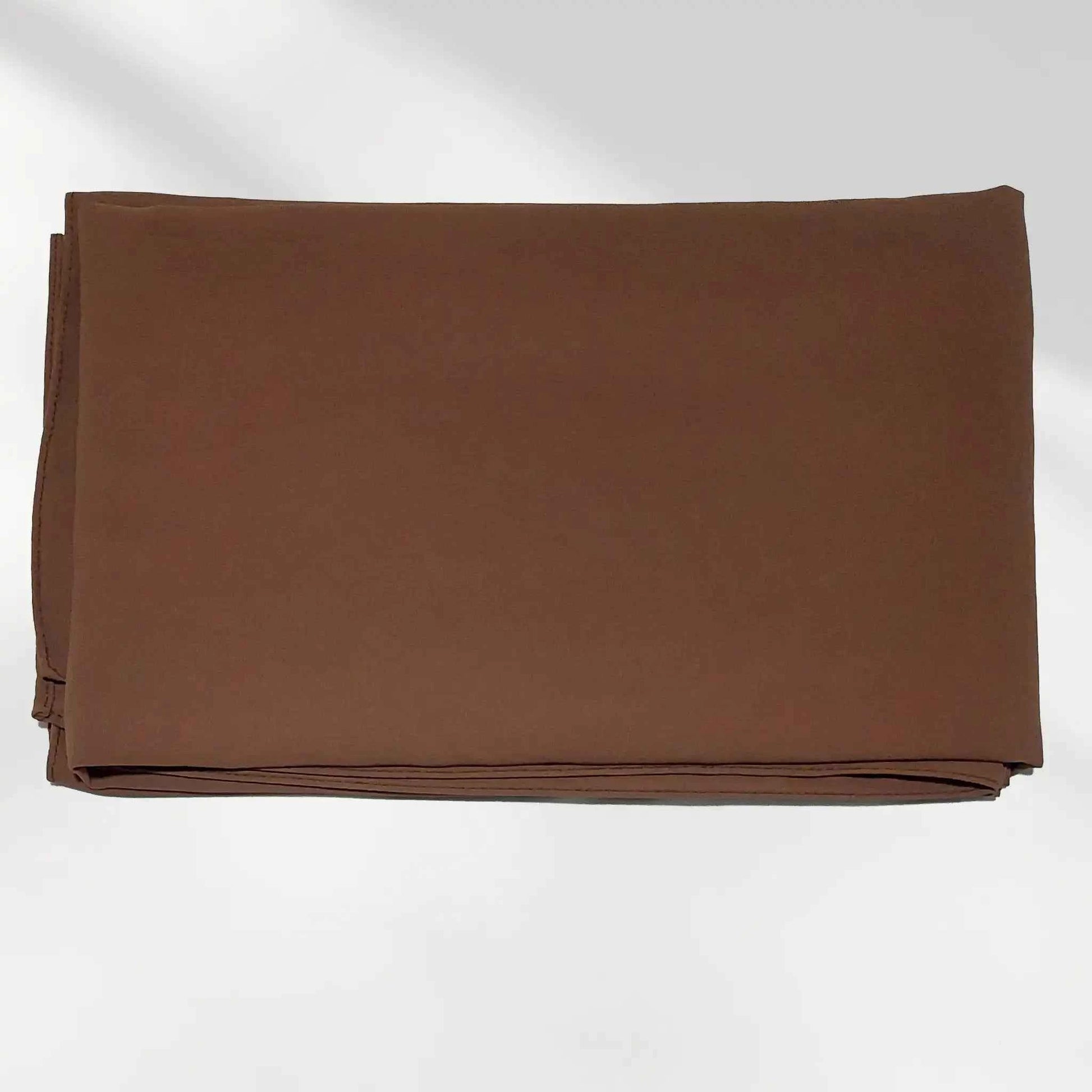 Folded chocolate brown chiffon hijab showing the fabric surface and finished edge