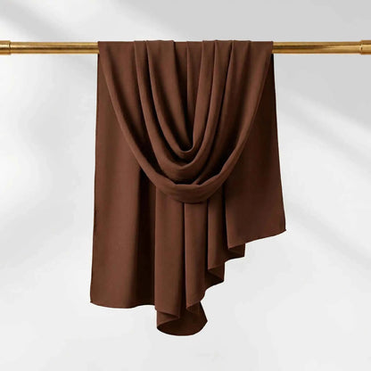 Chocolate brown chiffon hijab scarf shown at full length draped over a gold rail