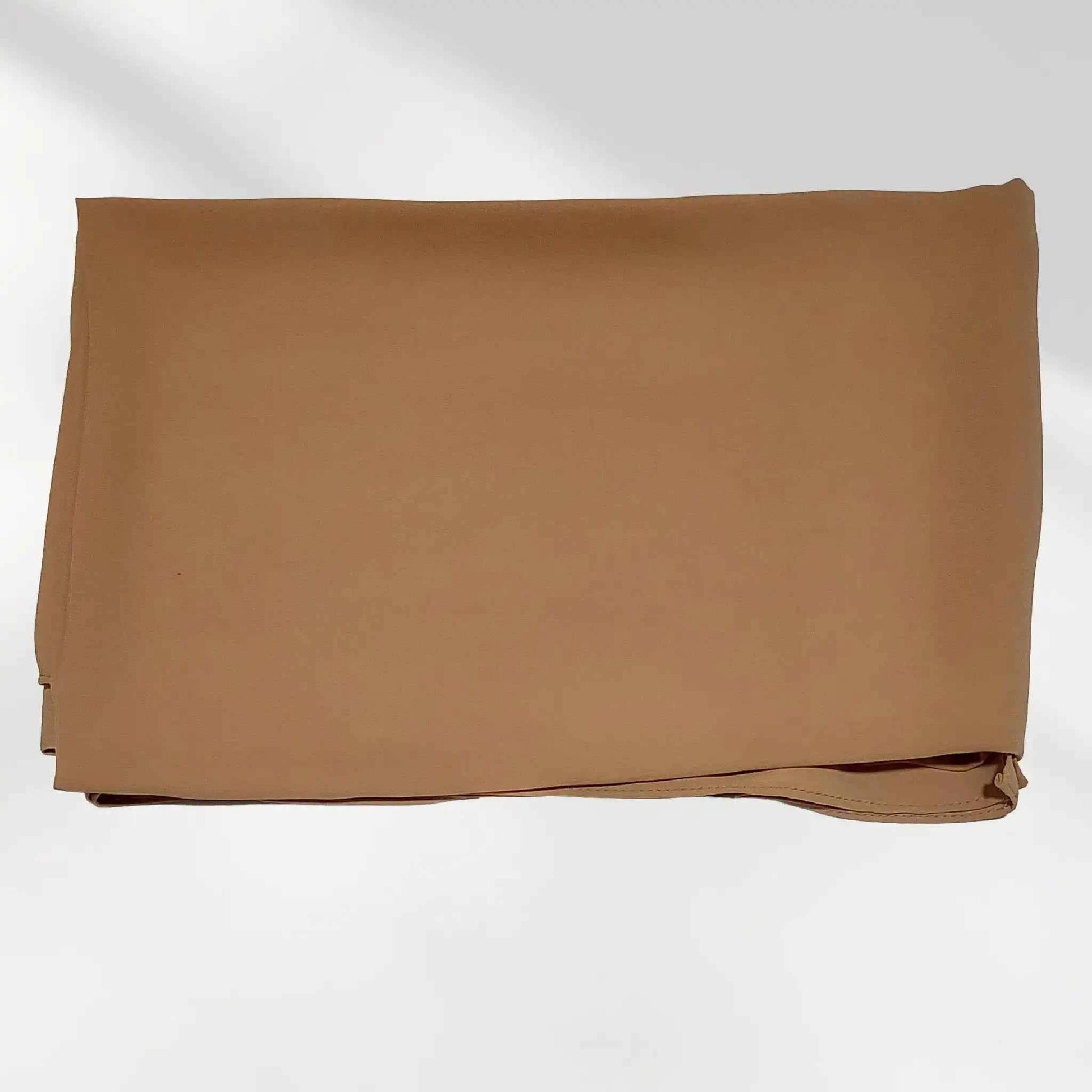 Folded brown chiffon hijab scarf laid flat displaying smooth fabric texture and stitched hem.
