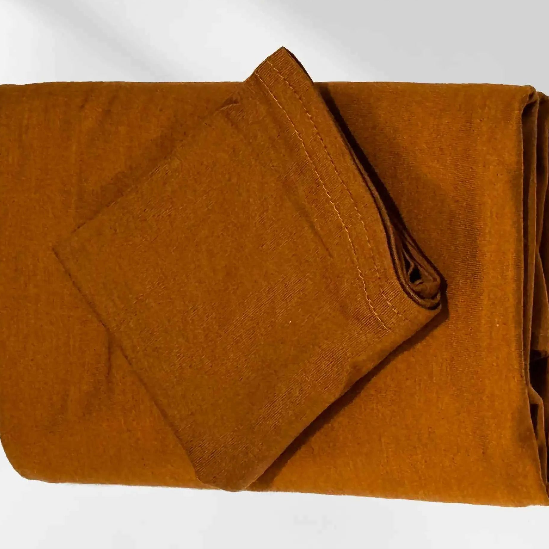 Gold jersey hijab folded with its matching hijab cap, shown as a complete set