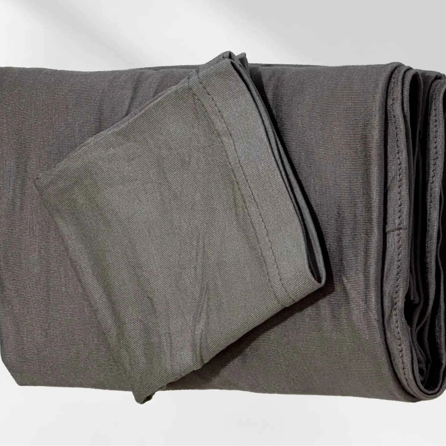 Gray jersey hijab folded with its matching hijab cap, shown as a complete set