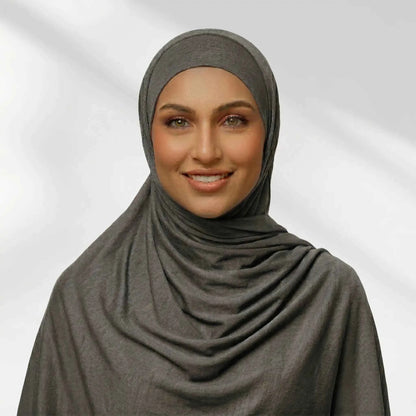 Woman wearing a gray jersey hijab draped for full chest coverage, front view