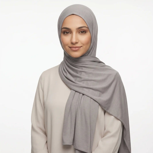 Woman wearing a grey jersey hijab with a cream top