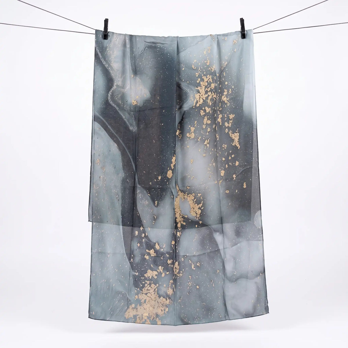 Full length grey marble print hijab hanging on a line, showing gold flecks across the print