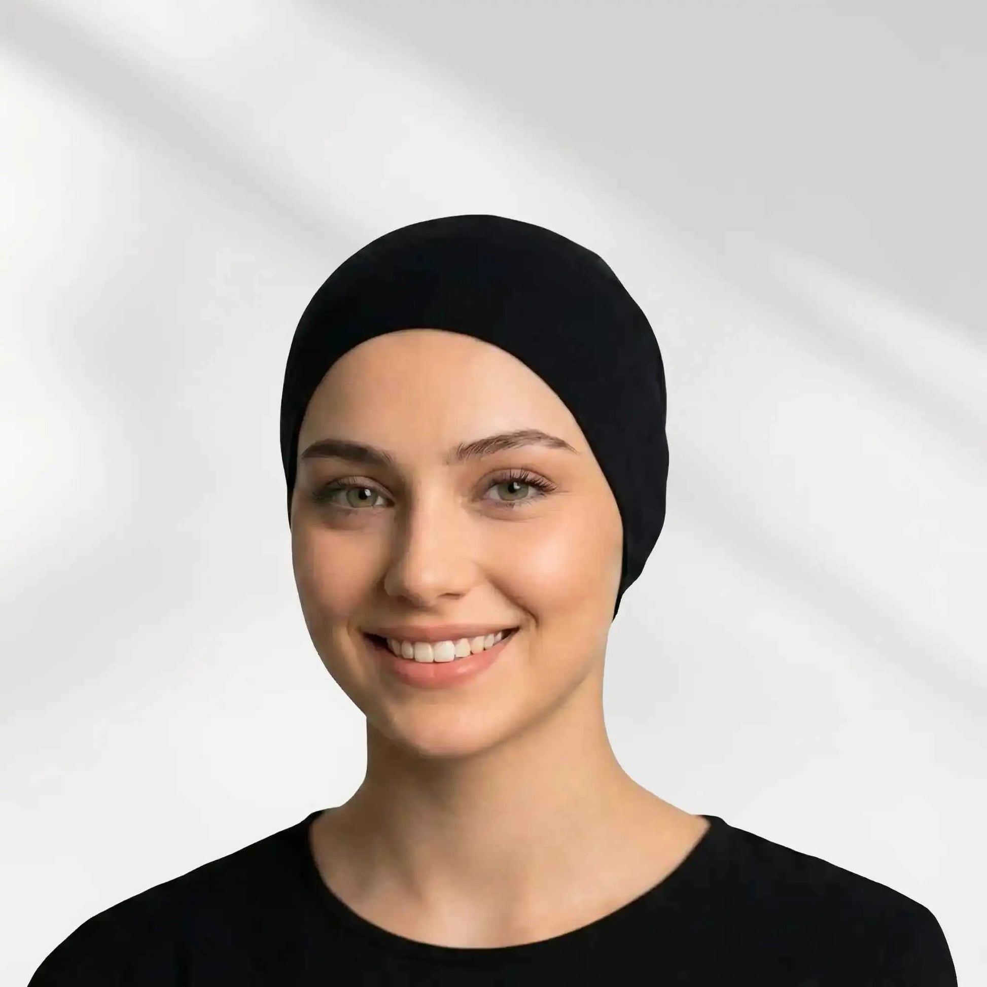 Woman wearing a black hijab undercap covering the hairline before wrapping
