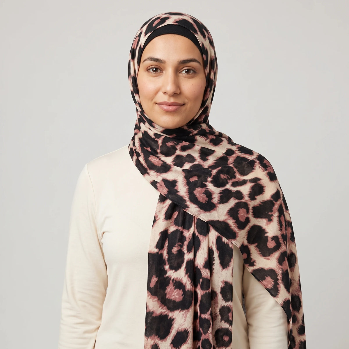 Woman wearing a leopard print hijab in black and dusty pink