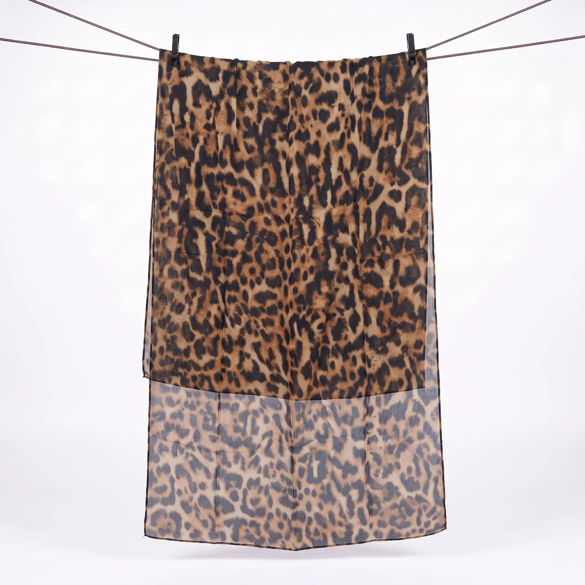 Full length hijab leopard print hanging on a line, showing black rosettes on a tan base