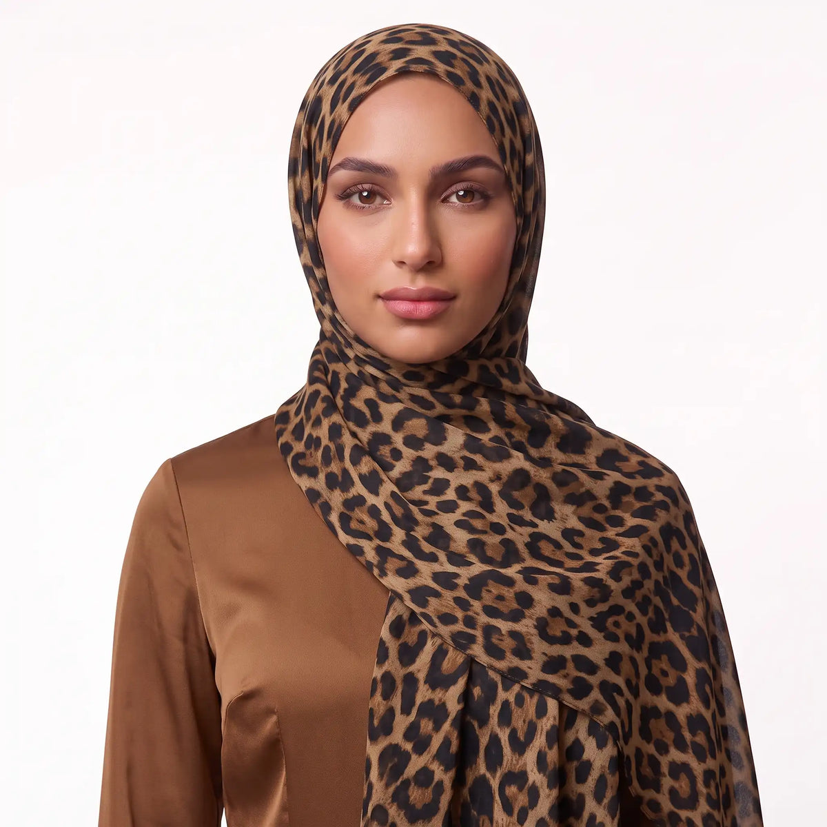 Woman wearing a leopard print modal hijab draped over the shoulder with a brown satin top
