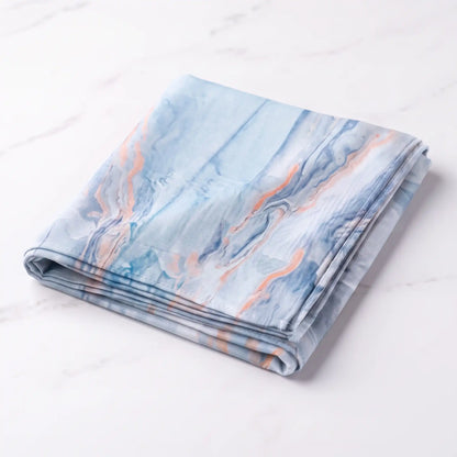 Folded light blue printed modal hijab with peach and deep blue marble veins on white marble