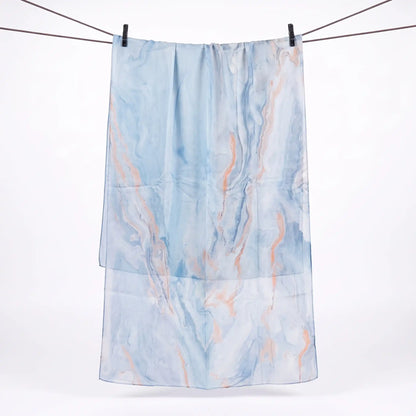 Full length light blue marble print hijab hanging on a line, showing soft peach veins across the print