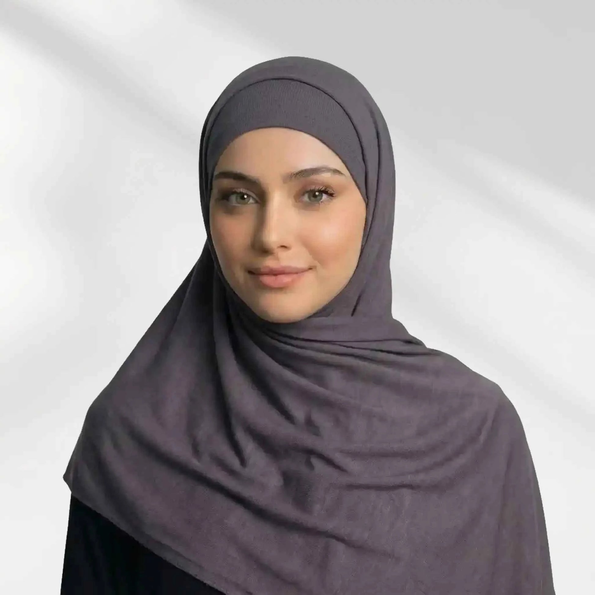 Woman wearing a mauve grey modal hijab draped over the shoulder with a matching undercap underneath
