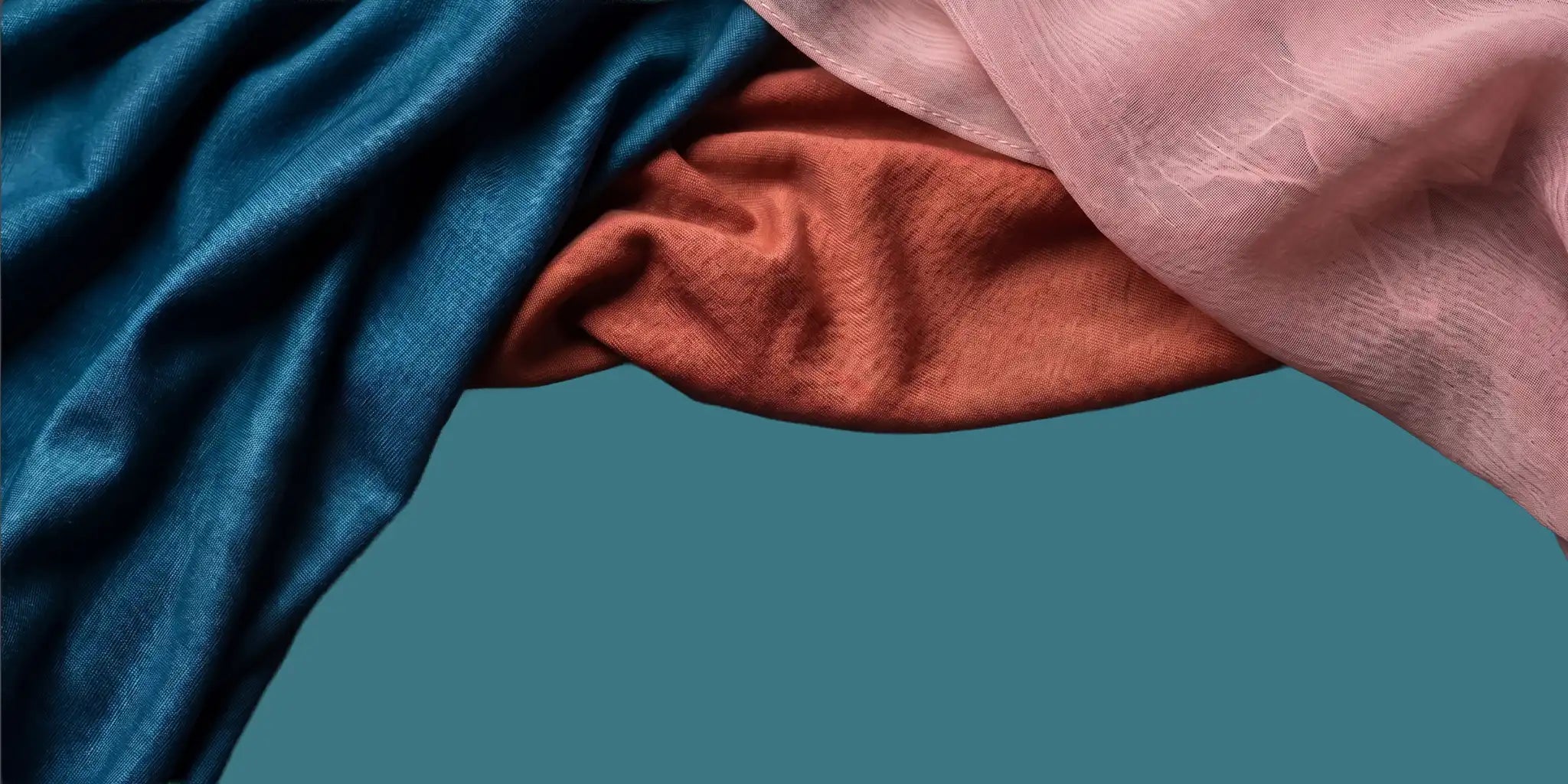 Close-up of blue, red, and pink fabric on a teal background at Wazi Empire