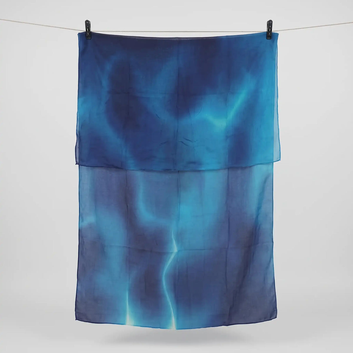 Full length blue ombre hijab in printed modal hanging on a line, cobalt fading to teal