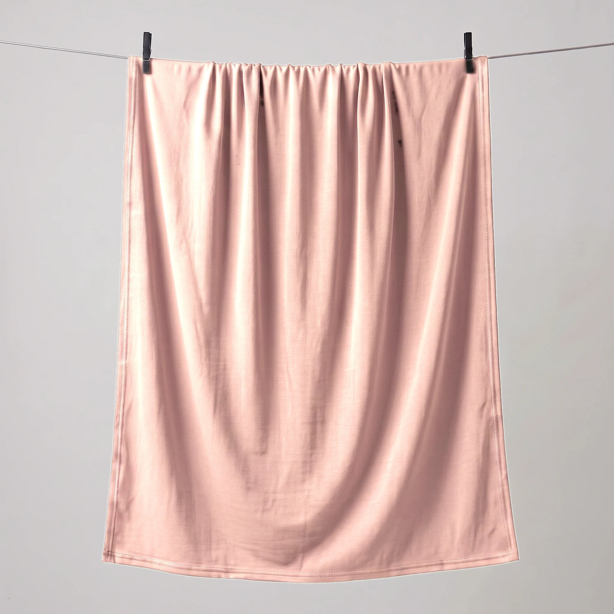 Full length light pink jersey hijab hanging on a line