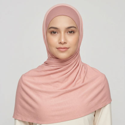 Woman wearing a light pink jersey hijab over a dusty pink hijab cap