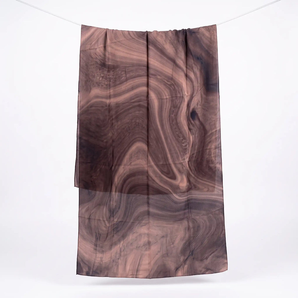 Full length brown printed modal hijab hanging on a line, showing the swirling print