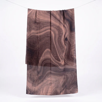 Full length brown printed modal hijab hanging on a line, showing the swirling print