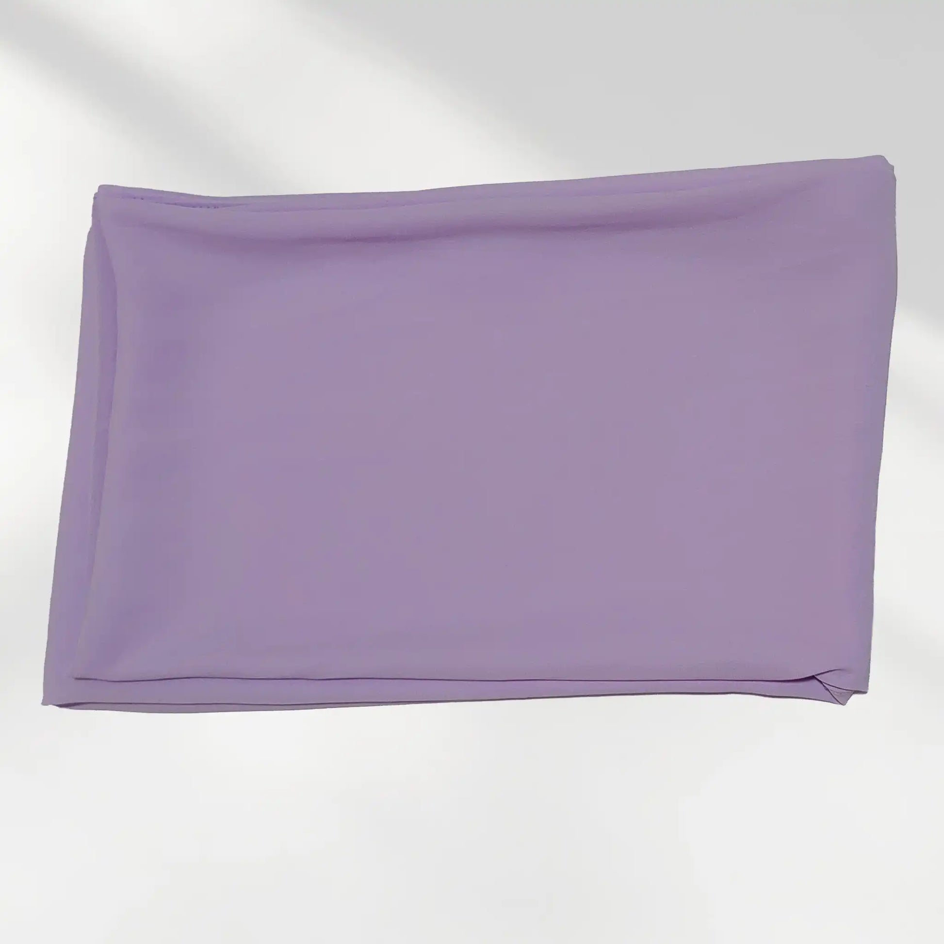 Folded purple chiffon hijab showing the fabric surface and color
