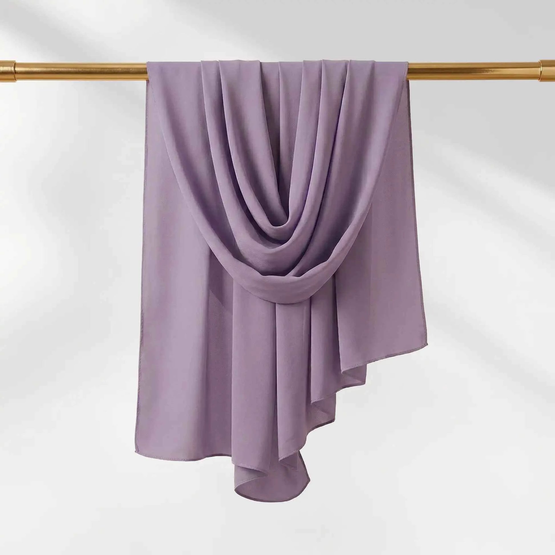 Full length purple chiffon hijab hanging on a gold rail showing the drape and finished edge