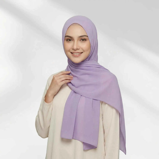 Woman wearing a purple chiffon hijab draped over one shoulder with a hijab undercap underneath