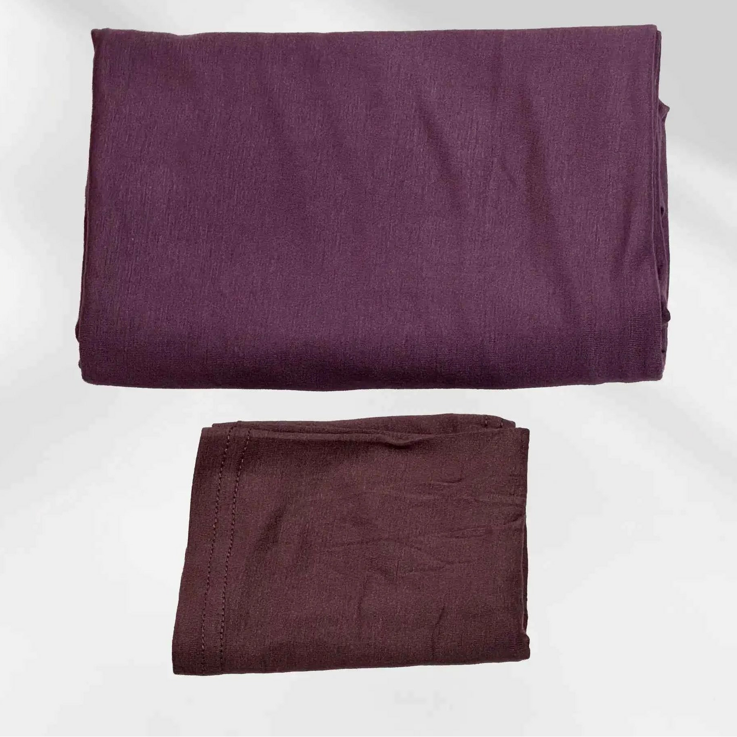 Purple jersey hijab and matching hijab cap laid flat, showing the soft stretch fabric and stitched cap edge