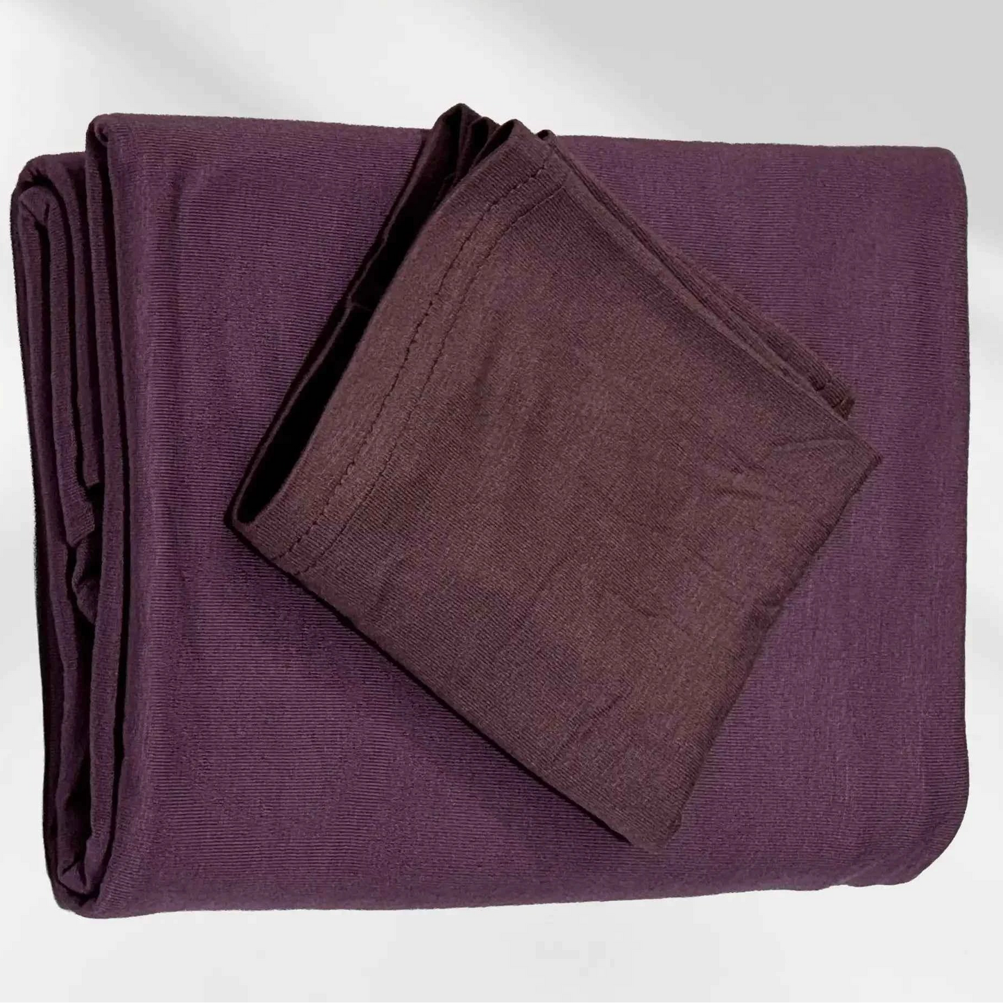 Purple jersey hijab folded with its matching hijab cap, shown as a complete set