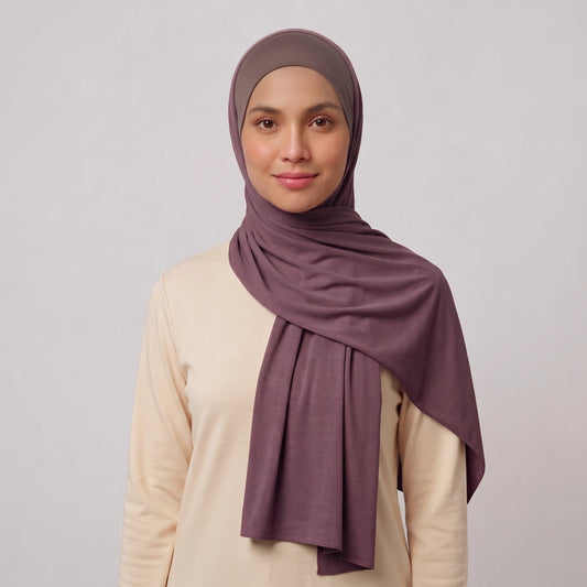 Woman wearing a purple jersey hijab over a taupe hijab cap