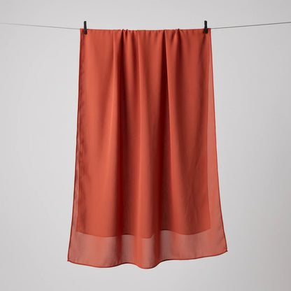 Red chiffon hijab hanging full length, showing the lightweight drape