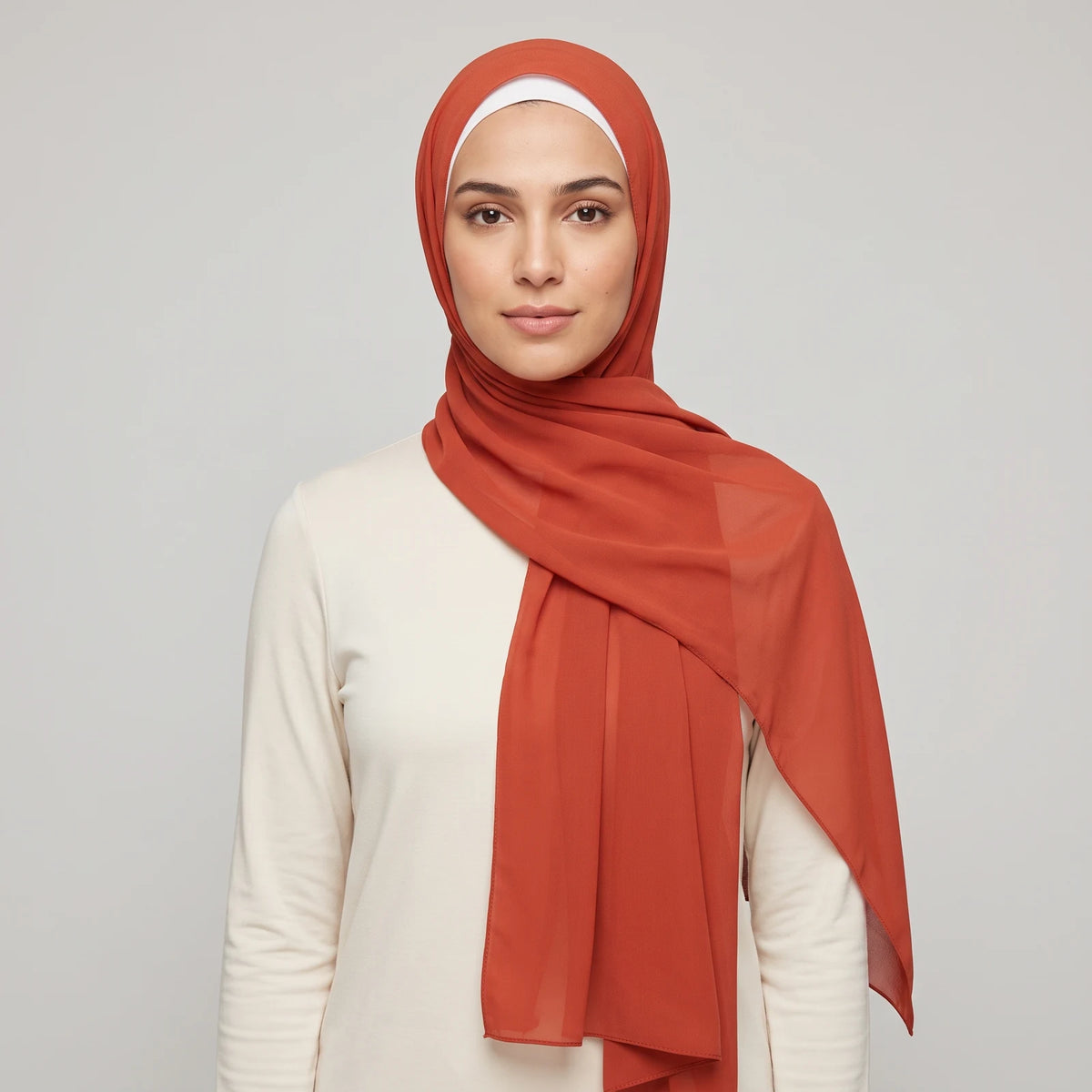 Woman wearing a red chiffon hijab over a white jersey hijab cap