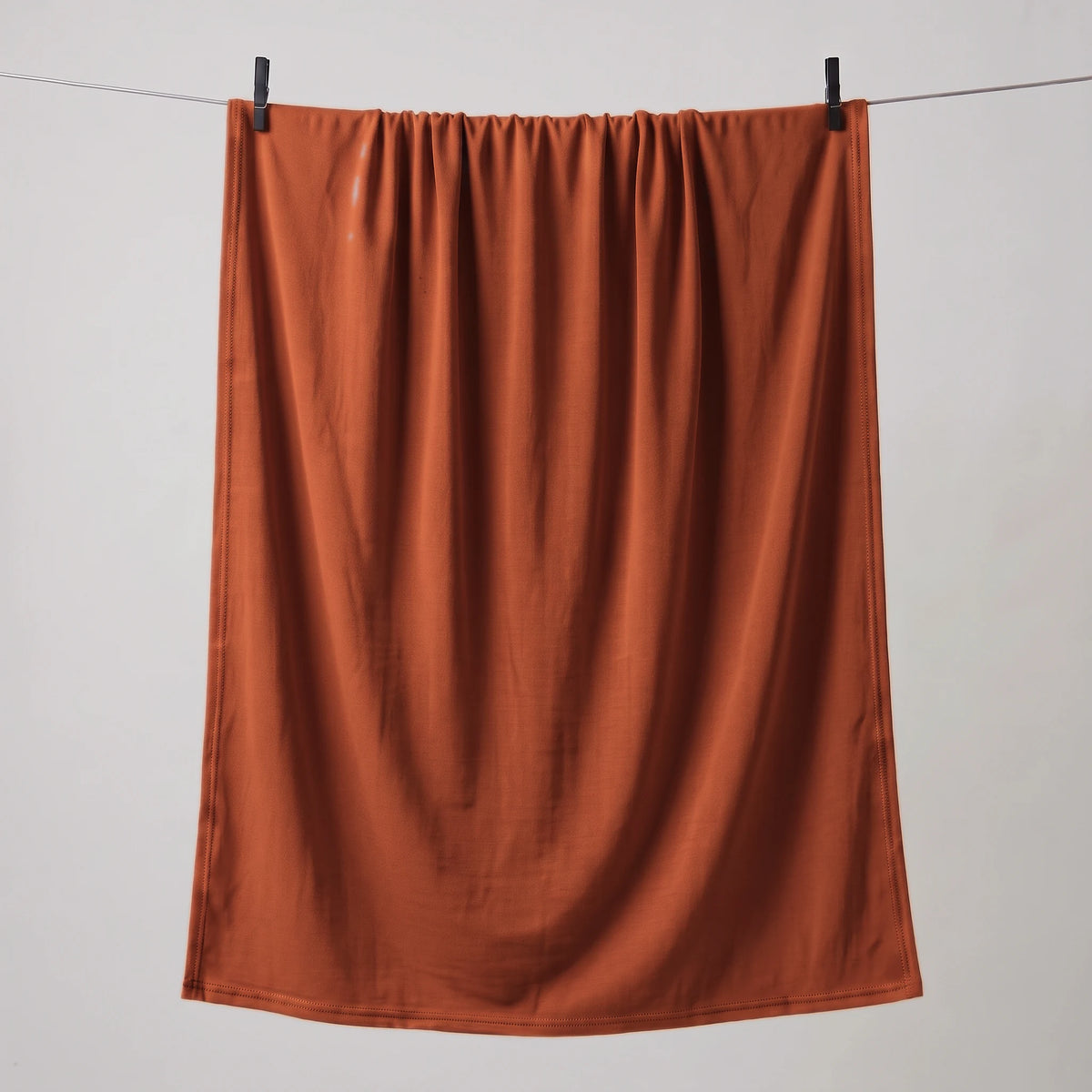 Full length red jersey hijab hanging on a line