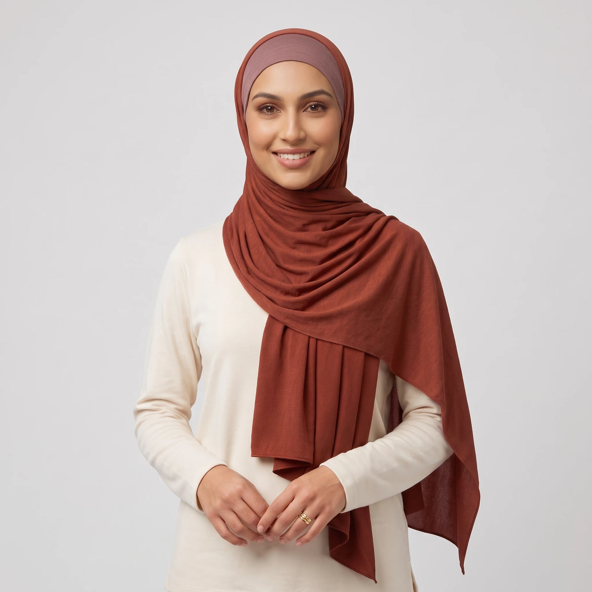 Woman wearing a red jersey hijab over a dusty pink hijab cap