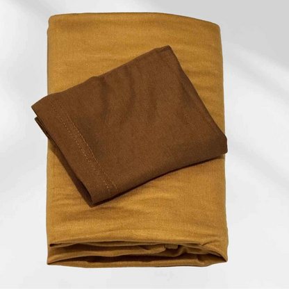 Yellow jersey hijab and brown hijab cap laid flat, showing the mustard scarf and the deeper cap shade