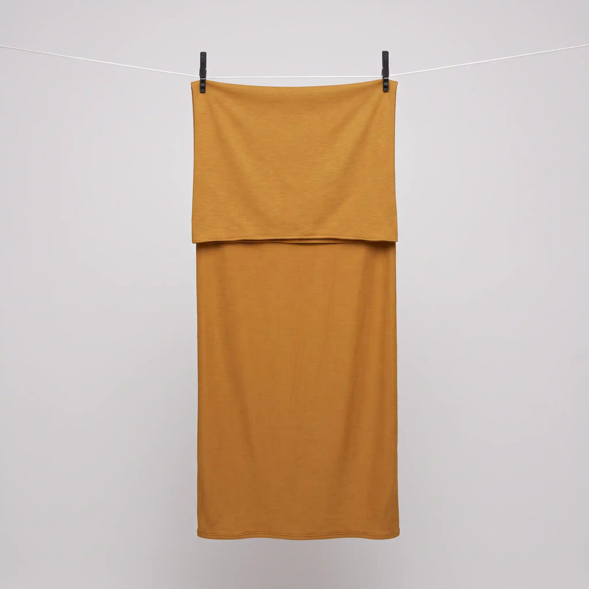 Full length yellow jersey hijab hanging on a line, warm golden yellow