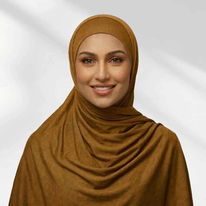 Woman wearing a yellow jersey hijab in a warm mustard tone, draped for full chest coverage